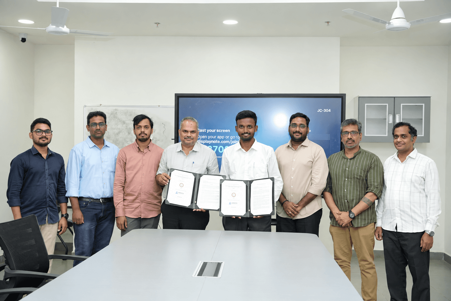 Representatives of Lakshya Smartguard Systems and SRM University–AP holding the MoU documents at the signing