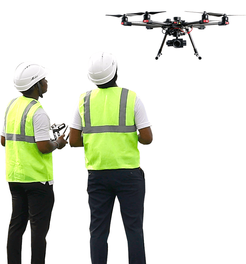 Two drone operators in safety vests watching a camera drone